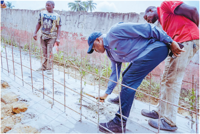 Delta State Commissioner for Works (Rural Roads) and Public Information, Mr. Charles Aniagwu taking space measurements in between drainage reinforcements, during the inspection of Orerokpe/Okuloho/Oviri-Okpe/Aragba road, yesterday.